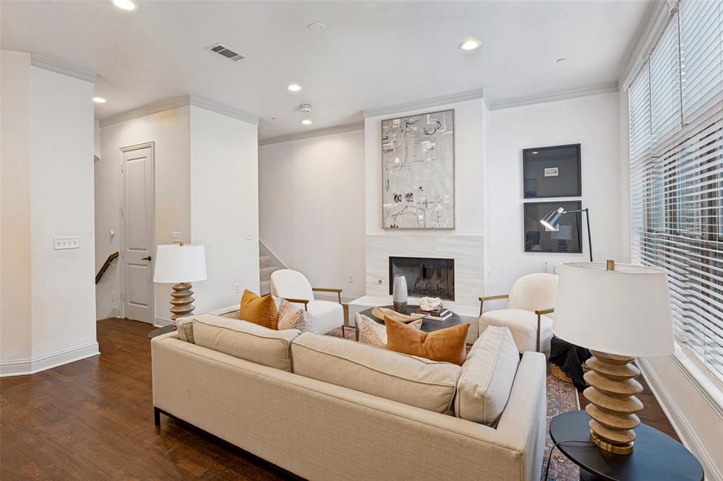 Living room view showing the  door to the half-bath and stairs down to the oversized garage and gas fireplace