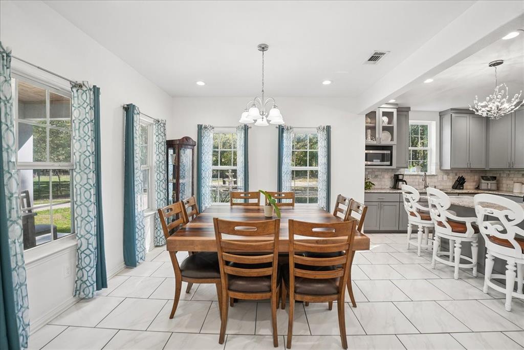 Dining area featuring large windows with natural light, recessed lighting, and tile flooring