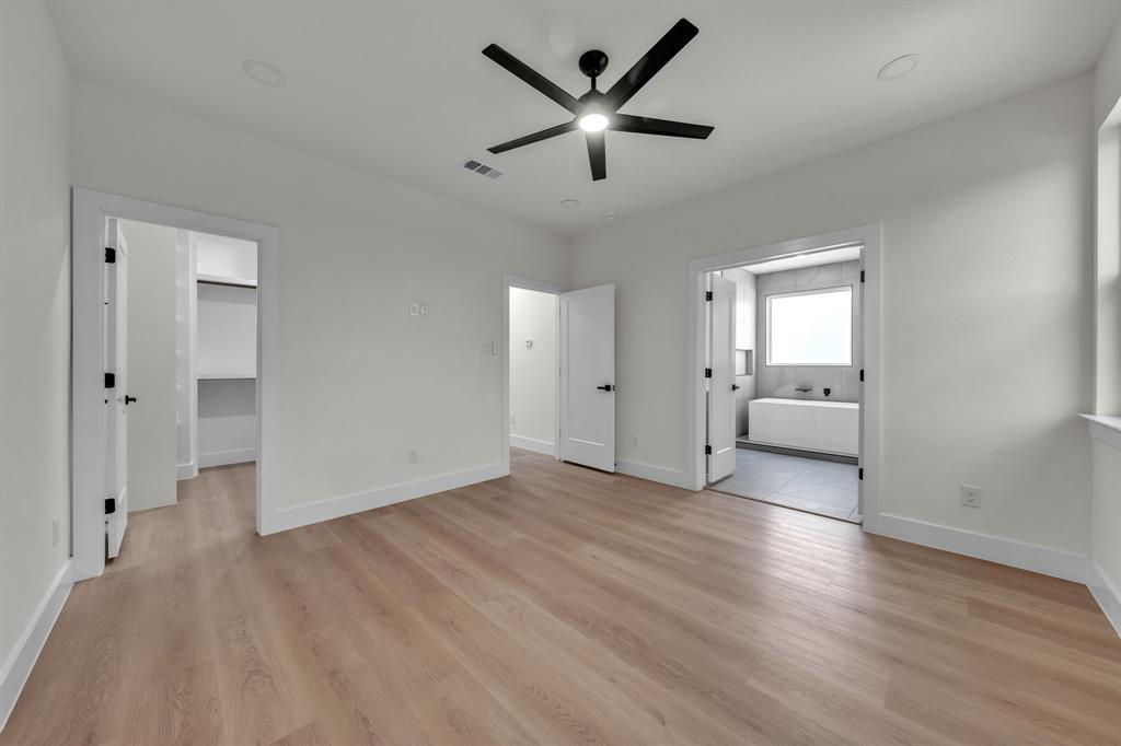 Neutral interior space featuring wood-finish flooring, recessed lighting, and a multi-blade ceiling fan with integrated lighting