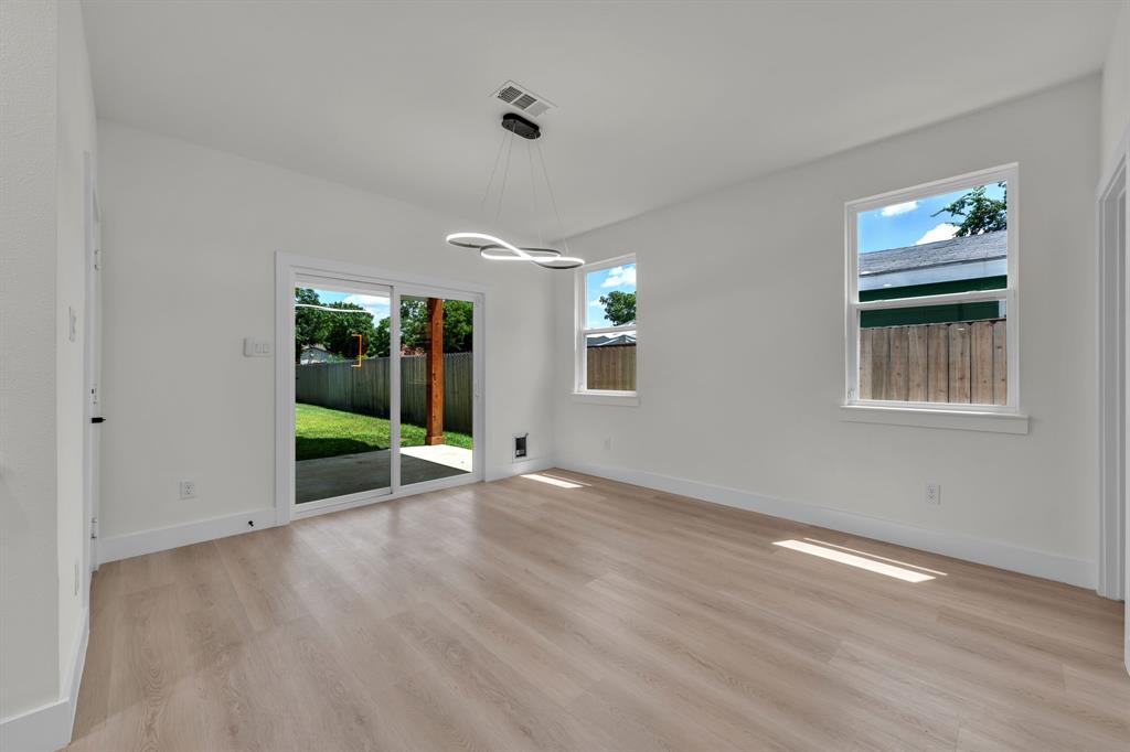 Interior space featuring wood-finish flooring, recessed lighting, double-pane windows, and sliding glass doors with direct access to a concrete patio