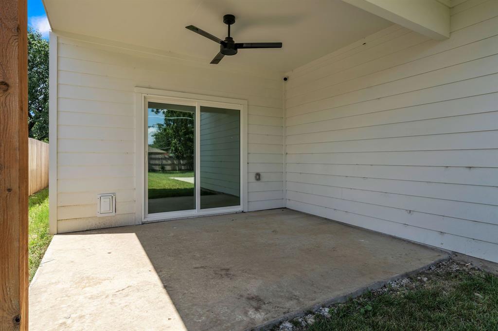 Covered patio featuring horizontal siding, a concrete floor, and a ceiling-mounted fan