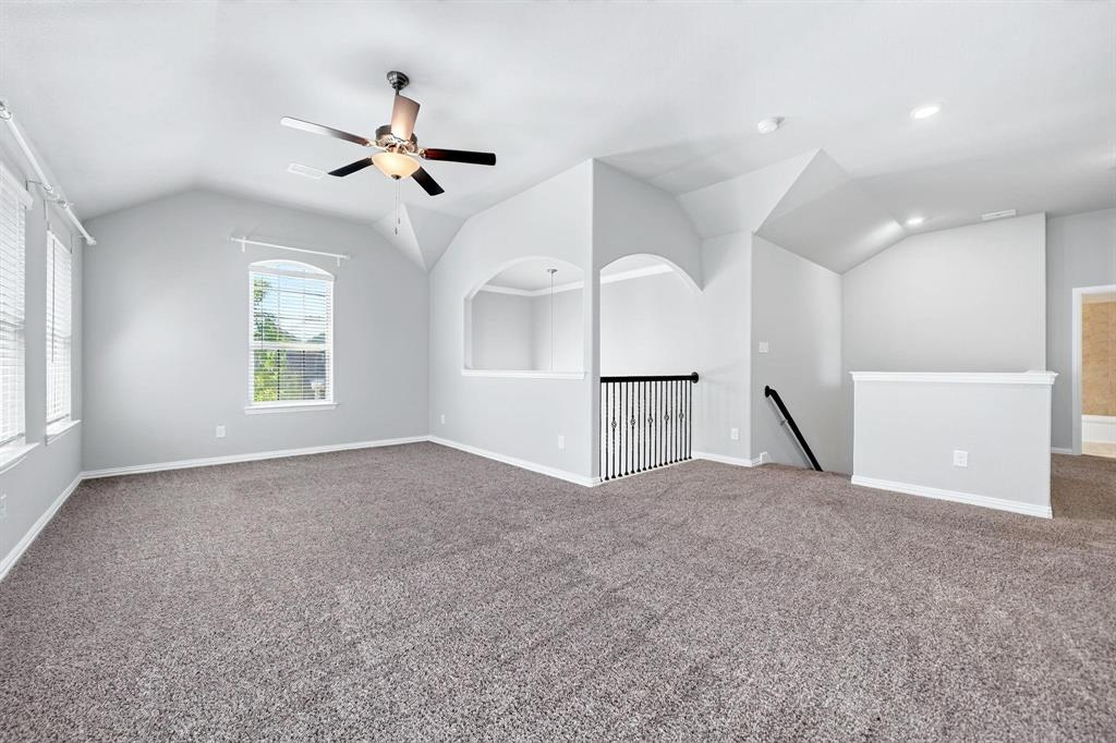 Vaulted ceilings with recessed lighting, wall-to-wall carpeting, archway architectural detailing, metal spindle railing, and a ceiling fan