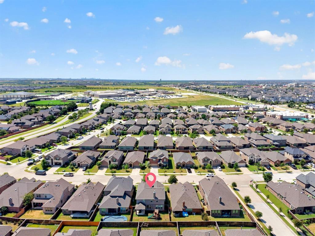 Aerial perspective of a multi-story residential property featuring a shingle roof, chimney, and enclosed rear yard