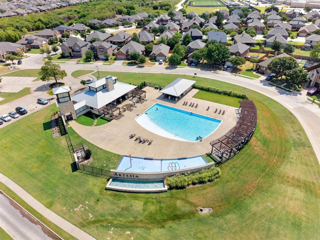Community amenity center featuring a swimming pool, covered pavilion, wooden pergola structures, and a dedicated water play area