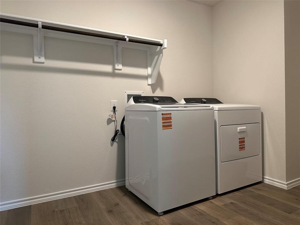 Laundry area featuring dark wood-style floors and washing machine and clothes dryer