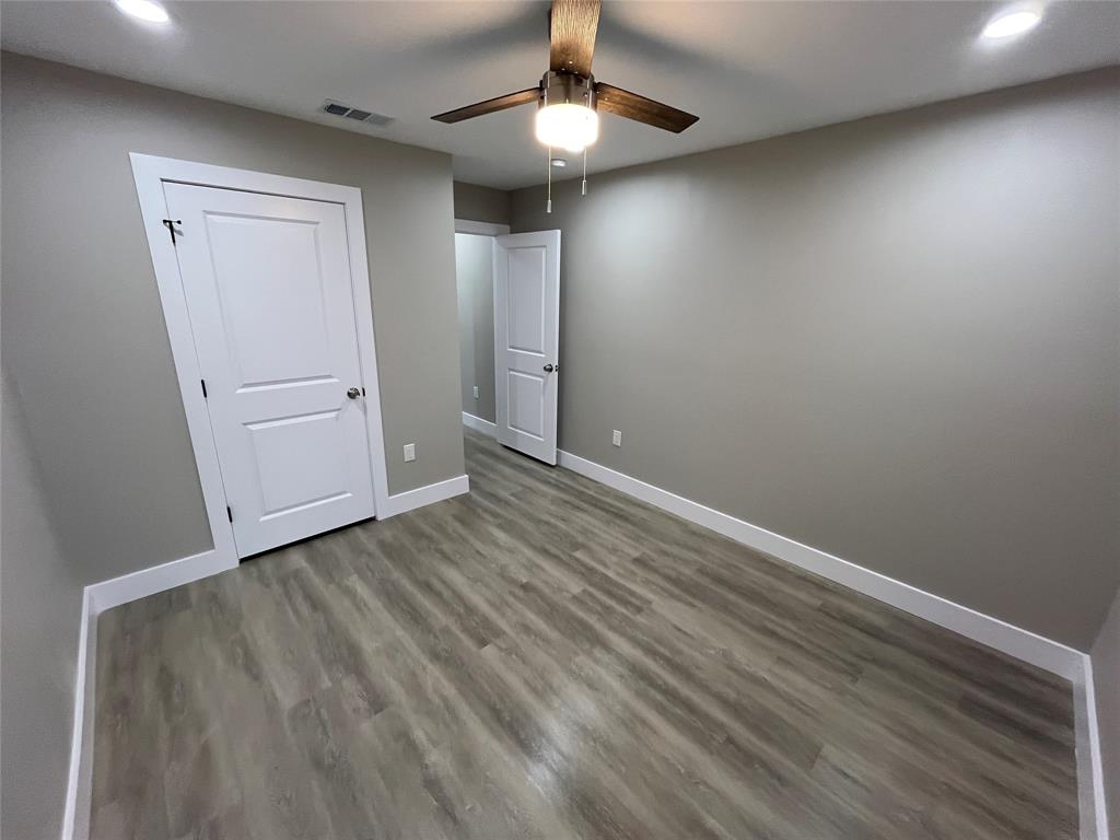 Neutral-toned interior featuring wood-finish flooring, recessed lighting, and a ceiling fan with integrated lighting