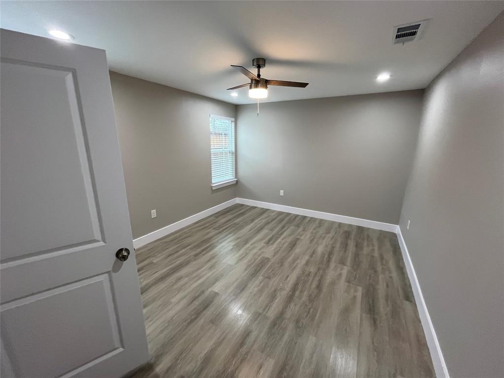 Interior space featuring wood-finish flooring, recessed lighting, a ceiling fan with integrated light fixture, and a single-hung window
