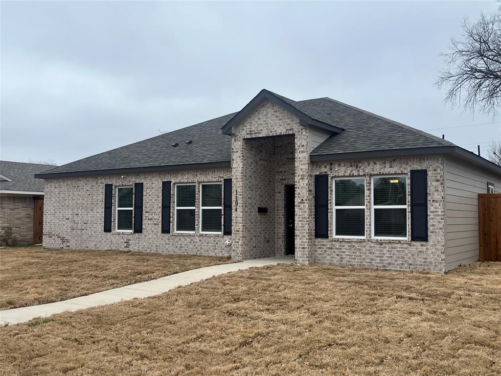 Single-story brick exterior featuring a covered entryway, decorative window shutters, and a hipped roofline Single-story brick exterior featuring a covered entryway, decorative window shutters, and a hipped roofline