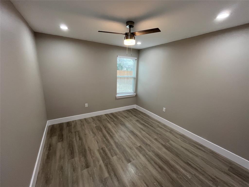 Neutral-toned interior featuring wood-finish flooring, recessed lighting, and a central ceiling fan with integrated lighting