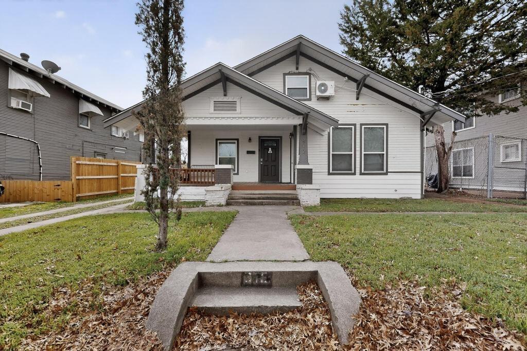 Craftsman-style exterior featuring a covered front porch with tapered columns, horizontal wood siding, a concrete walkway, and gable roofline details