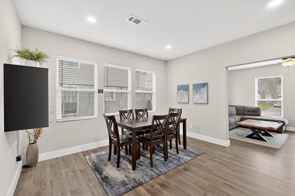 Neutral-toned interior featuring wood-finish flooring, recessed lighting, and a triple-window configuration