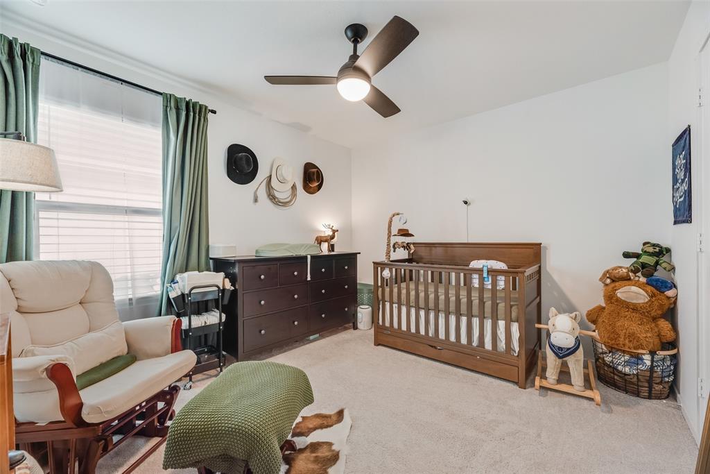 Neutral-toned carpeting, matte black ceiling fan with integrated lighting, and window with built-in rod