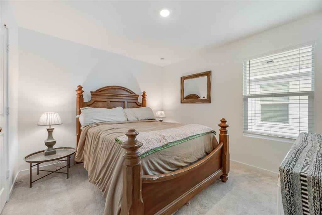 Neutral-toned interior space featuring recessed ceiling lighting, light carpeting, and a window fitted with horizontal blinds