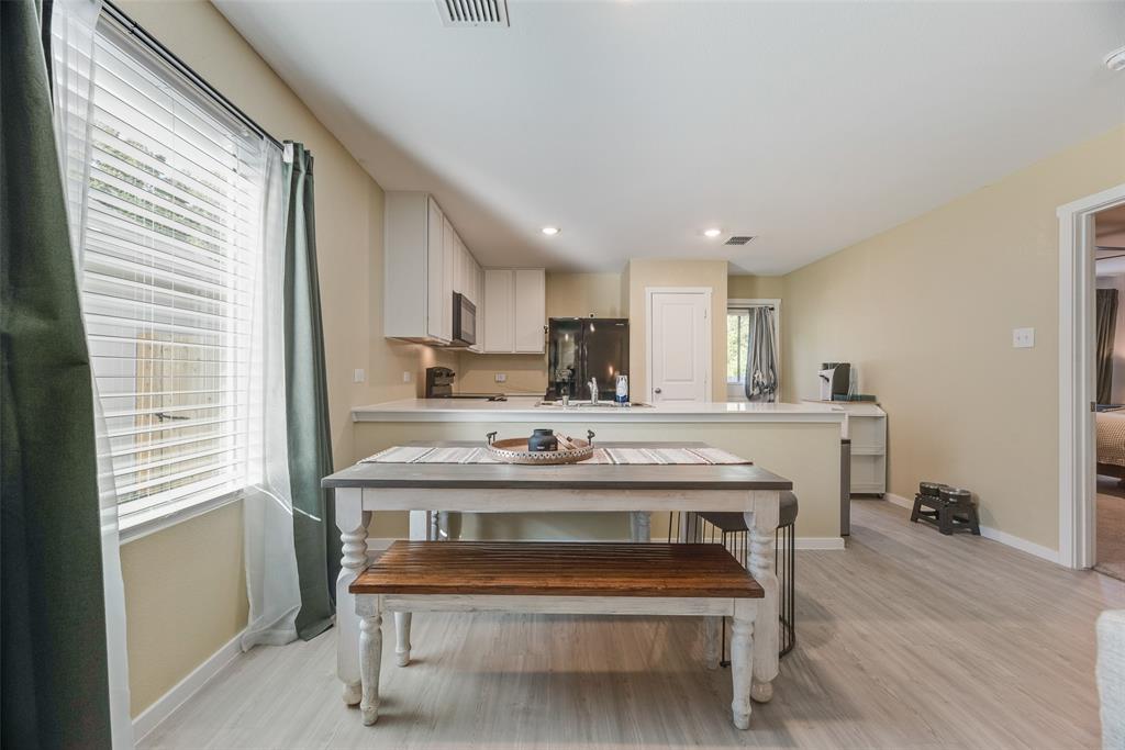 Kitchen featuring white cabinetry, solid-surface countertops, recessed lighting, and wood-finish flooring