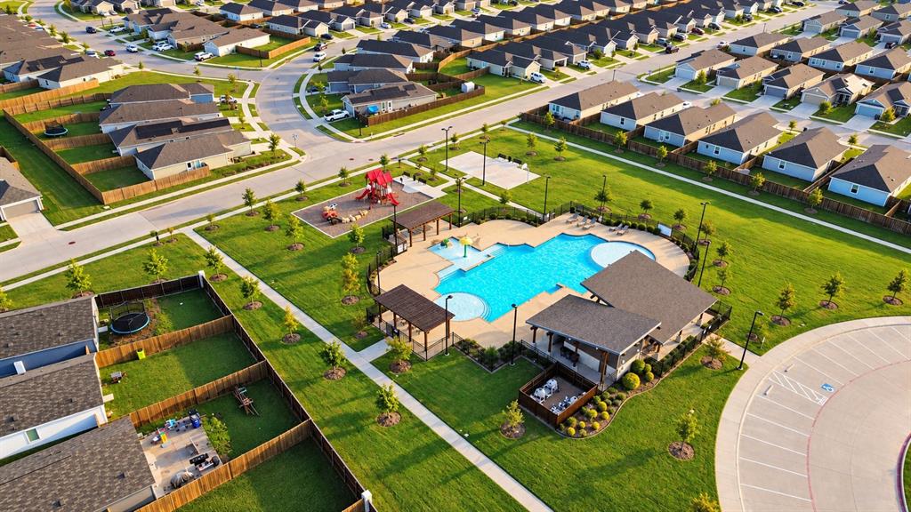 Community recreational area featuring a swimming pool, covered pavilion with built-in outdoor kitchen, playground, and sports court