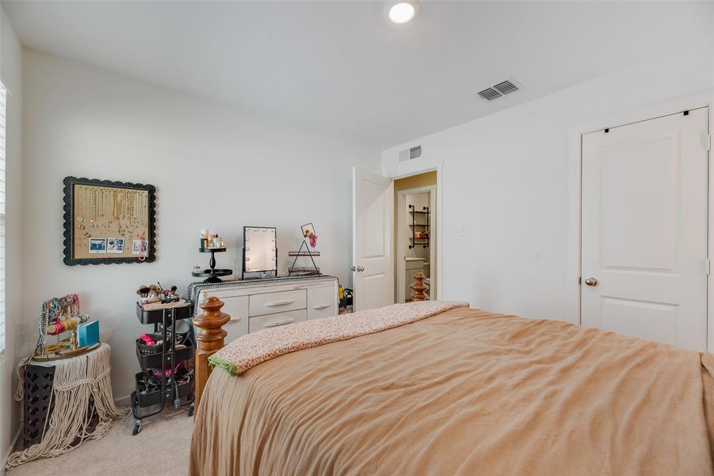 Neutral wall tones, recessed lighting, and wall-to-wall carpeting featuring a solid-panel door and entry to a secondary space