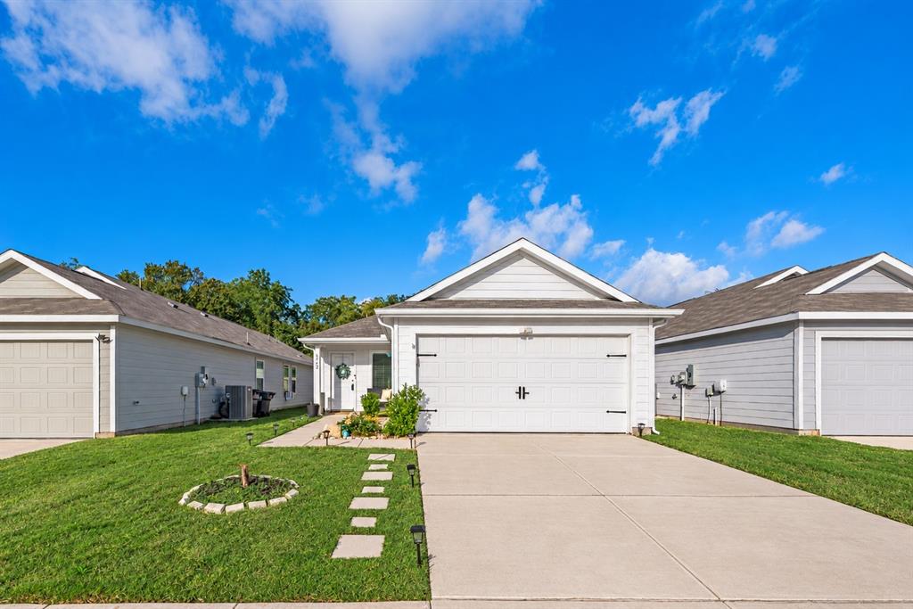 Single-story residence featuring light-toned horizontal siding, a gabled roofline, a concrete driveway, and an attached two-car garage Single-story residence featuring light-toned horizontal siding, a gabled roofline, a concrete driveway, and an attached two-car garage