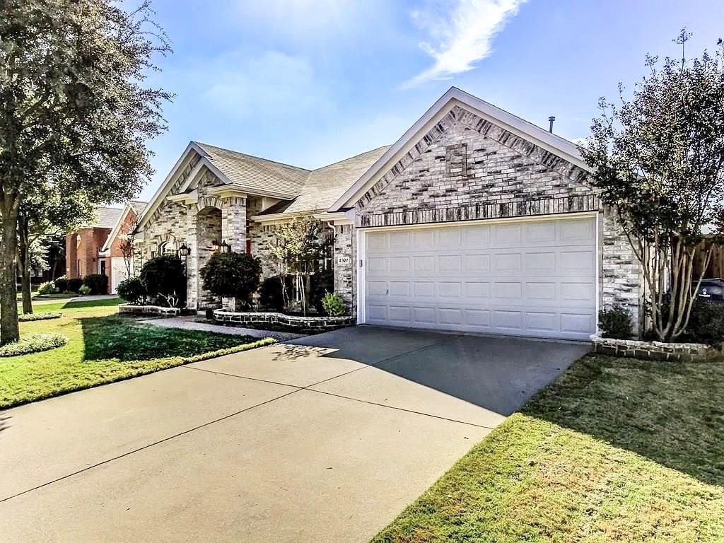 Multi-gabled exterior featuring brick masonry, a double-car garage, and concrete driveway