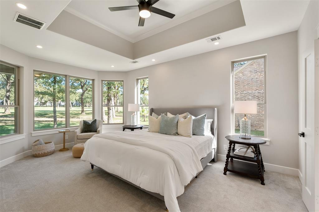 Expansive en-suite primary suite with sitting area and panoramic windows with serene views