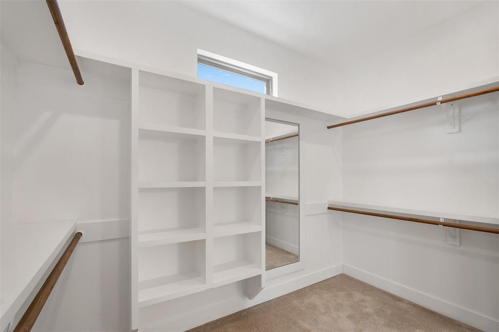 Large walk-in closet featuring built-in organizers