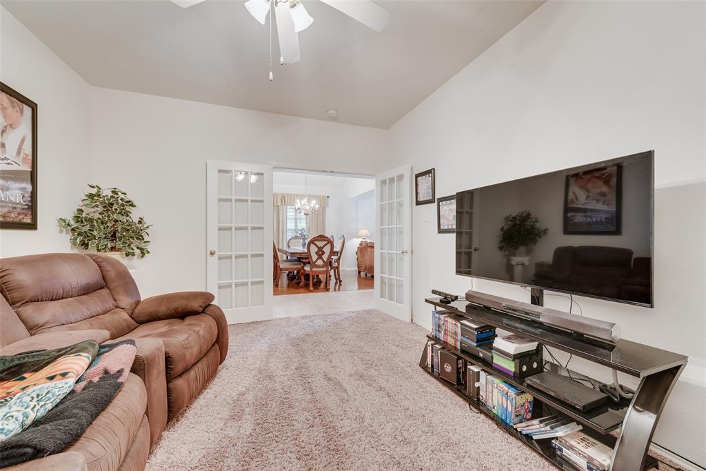 Room featuring neutral wall finishes, carpeting, a ceiling fan, and white French doors with glass panes
