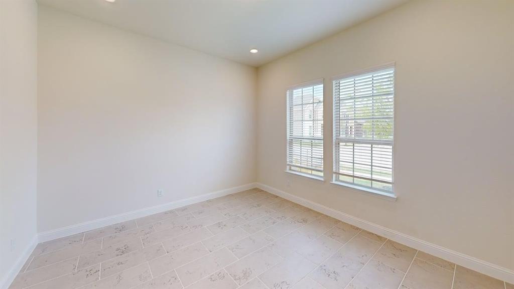 Neutral-toned interior room featuring tile flooring, recessed ceiling lighting, and dual windows with fitted horizontal blinds