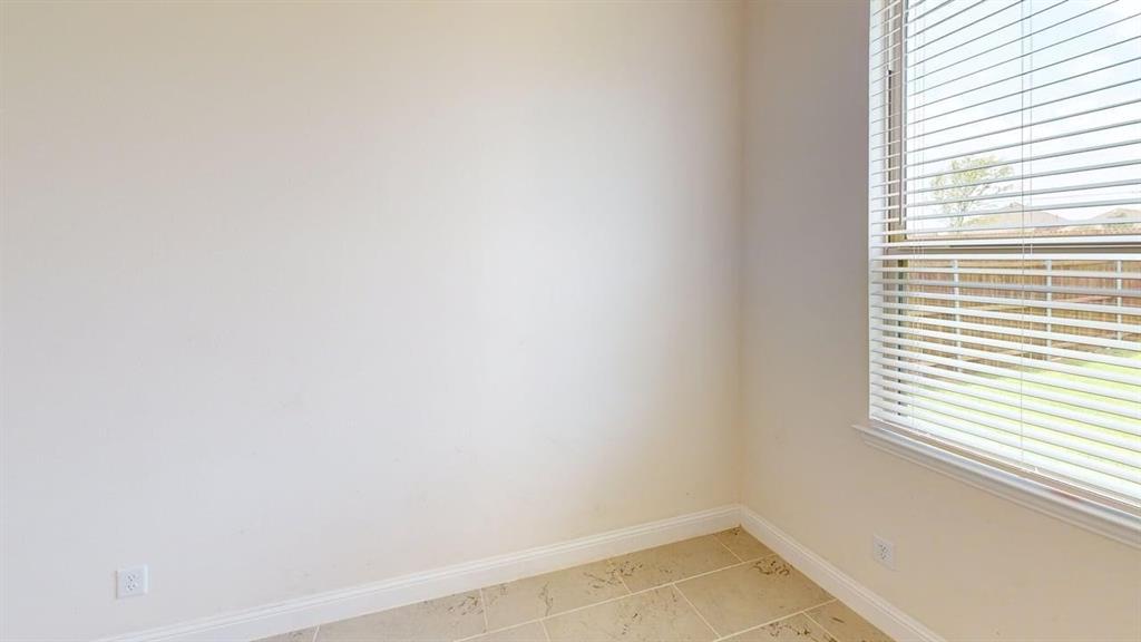 Neutral-toned walls, tile flooring, and a window fitted with horizontal blinds
