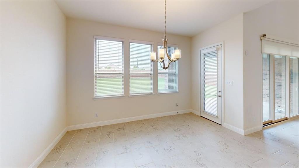 Neutral-toned tile flooring, three large windows with integrated blinds, a metal chandelier, and glass-paneled exterior doors