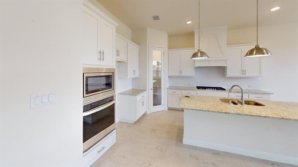 Kitchen featuring white cabinetry, stone-surface countertops, stainless steel wall-mounted oven and microwave, recessed lighting, and metal pendant light fixtures