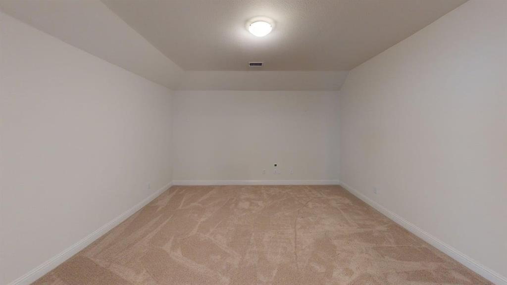 Neutral-toned room featuring high tray ceilings, plush wall-to-wall carpeting, and a central flush-mount ceiling light fixture