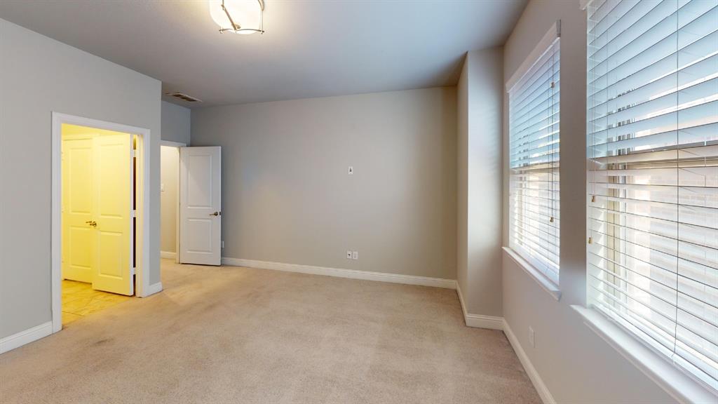 Neutral-toned interior featuring wall-to-wall carpeting, multi-pane windows with horizontal blinds, recessed ceiling lighting, and solid-core interior doors