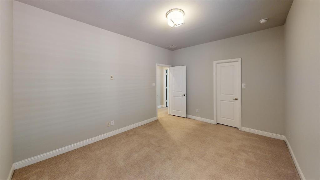 Neutral wall-toned room featuring beige carpeting, neutral wall paint, a six-panel door, and a flush-mount ceiling light fixture
