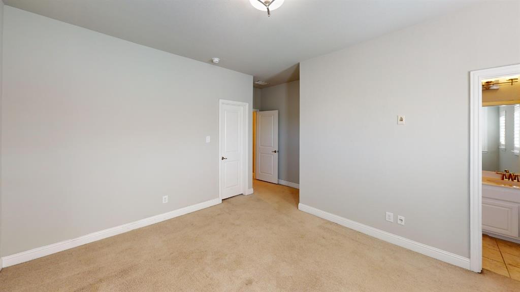 Interior room featuring neutral wall paint, wall-to-wall carpeting, two interior panel doors, and a ceiling-mounted light fixture