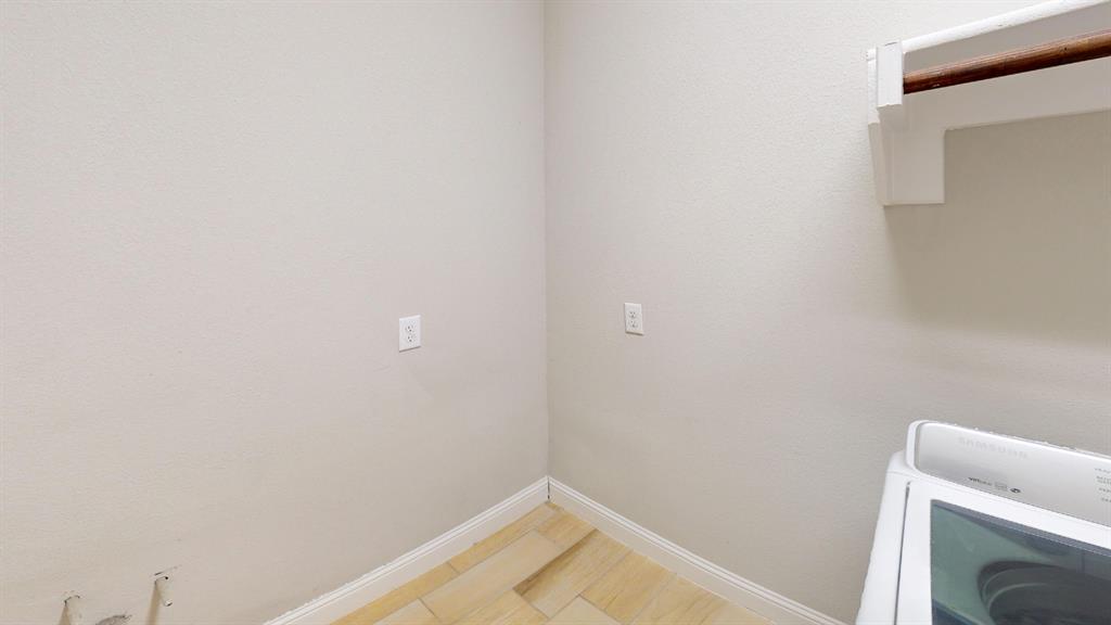 Neutral-toned walls, wood-finish flooring, and a built-in wooden shelving rod Neutral-toned walls, wood-finish flooring, and a built-in wooden shelving rod