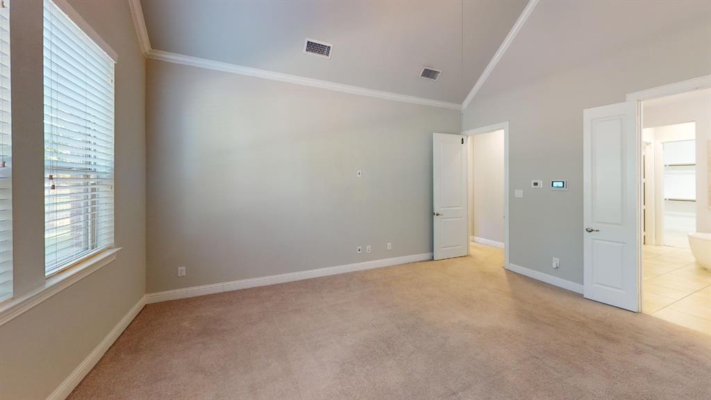 Vaulted ceiling featuring neutral wall paint, carpeting, and multi-panel interior doors