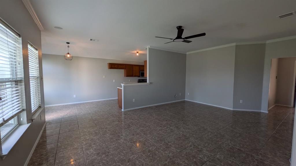 Open-concept interior featuring large-format tile flooring, recessed lighting, a modern ceiling fan, and crown molding Open-concept interior featuring large-format tile flooring, recessed lighting, a modern ceiling fan, and crown molding