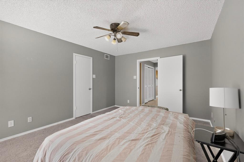 Carpeted flooring, neutral wall paint, ceiling fan light fixture, and white interior doors