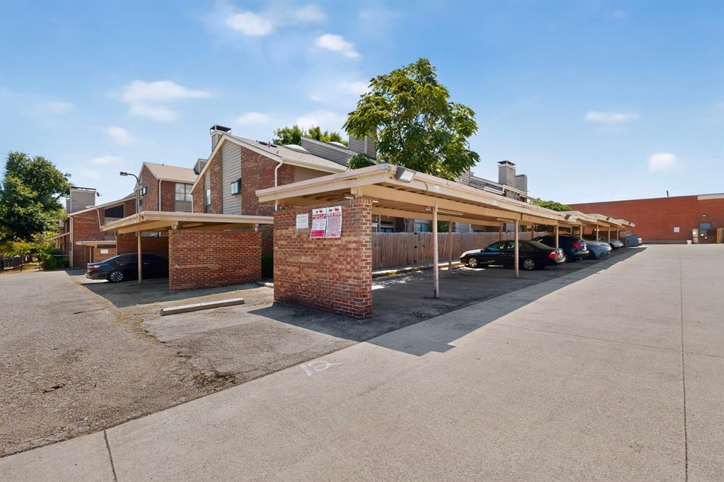 Covered parking structures with brick supports and metal roofing