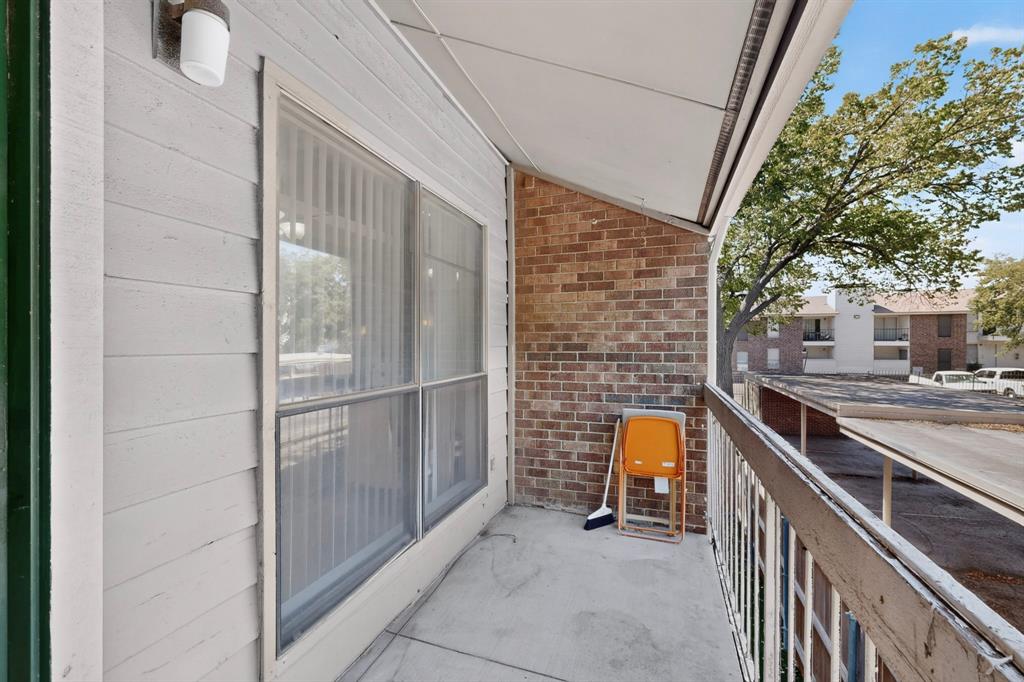 Private balcony featuring concrete flooring, brick and siding exterior, and a white railing