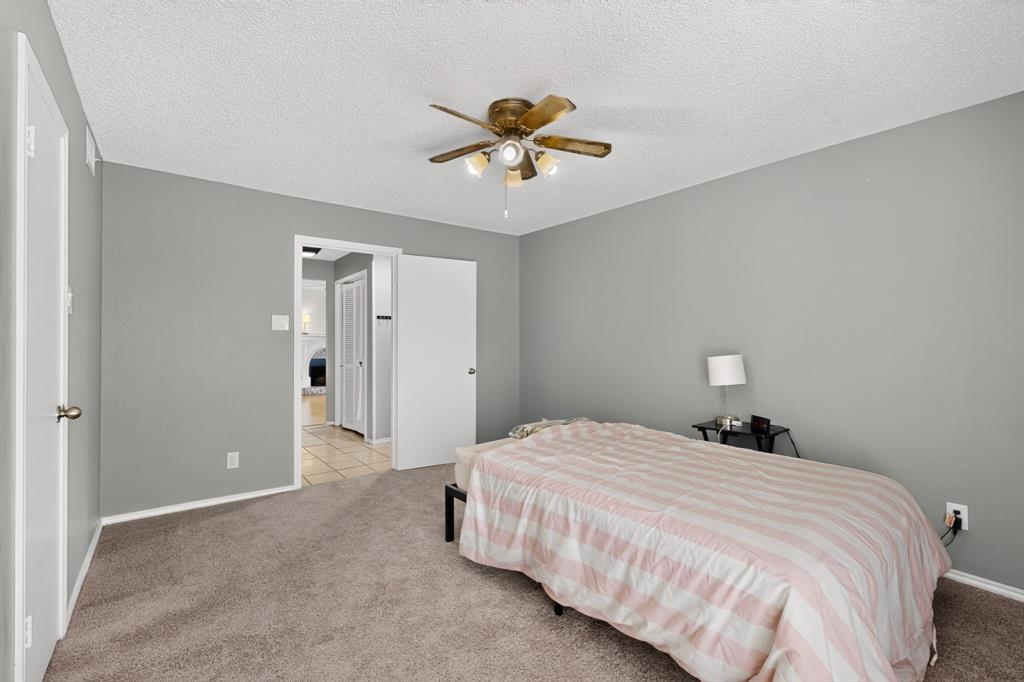 Wall-to-wall carpeting, ceiling fan with integrated lighting, and painted walls
