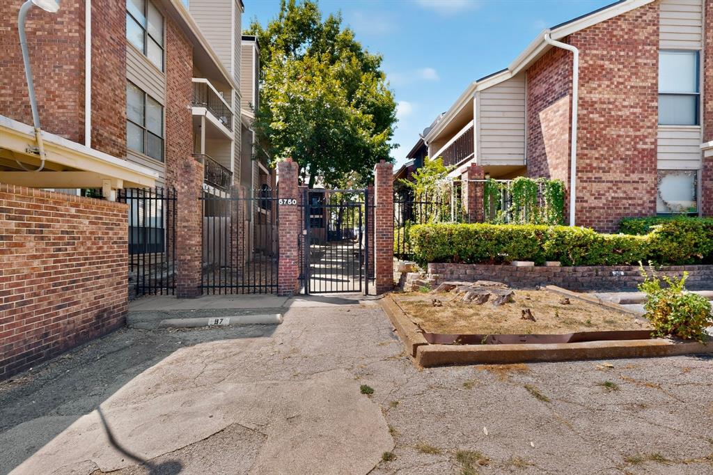 Brick exterior construction with an ornamental wrought-iron pedestrian gate and vehicular gate