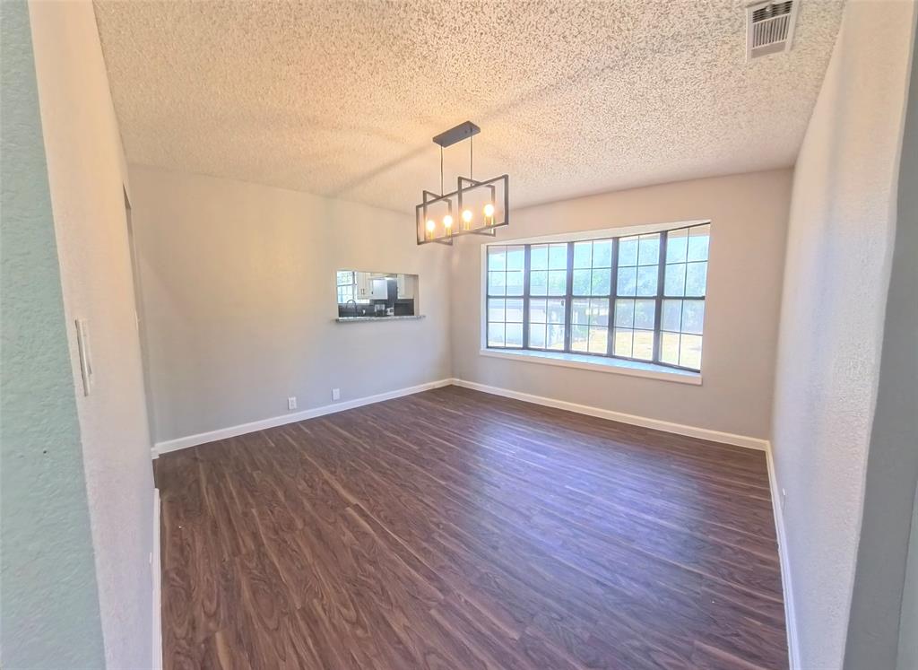 Wood-finish flooring, multi-pane bay window, and matte black geometric chandelier