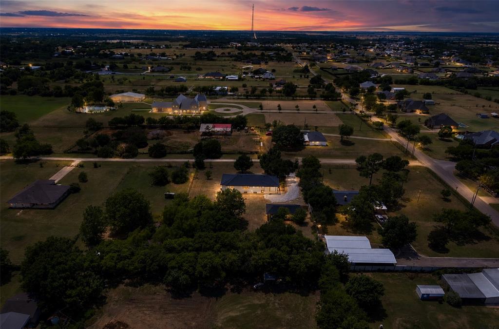 Aerial perspective featuring expansive acreage, mature tree clusters, and a paved circular driveway Aerial perspective featuring expansive acreage, mature tree clusters, and a paved circular driveway