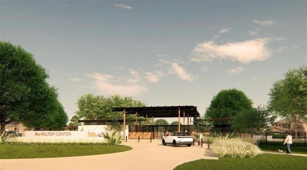 The Hilltop Center featuring a covered pavilion with timber-frame construction, stone accent walls, integrated landscaping, and paved drive entry