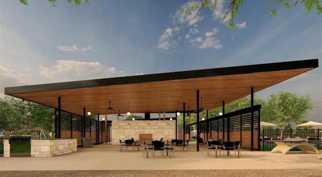 Covered outdoor pavilion featuring a cantilevered roof with wood-finished ceiling, stone-clad fireplace, integrated ceiling fans, and slatted privacy screens