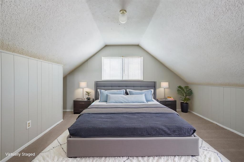 Vaulted ceiling featuring a single flush-mount light fixture and light-toned wall paneling
