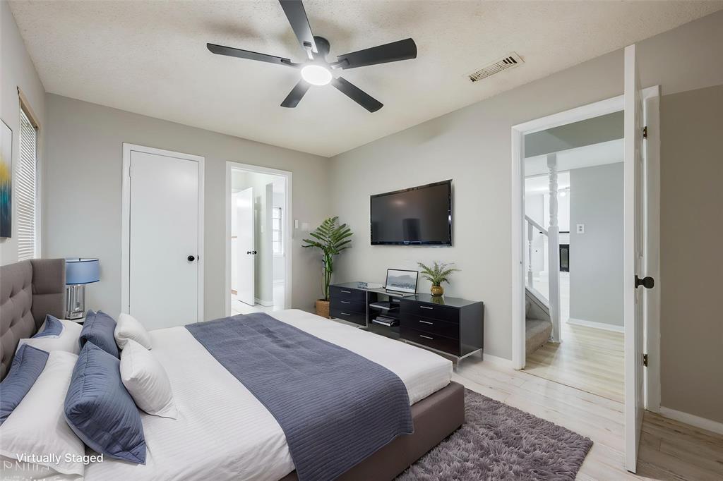 Neutral interior featuring light-toned flooring, multi-blade ceiling fan with integrated lighting, and solid-core interior doors