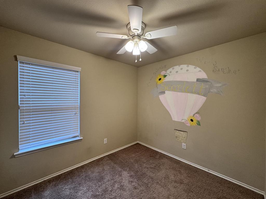 Interior space featuring neutral wall paint, carpeted flooring, a multi-blade ceiling fan with integrated light fixture, and horizontal window blinds