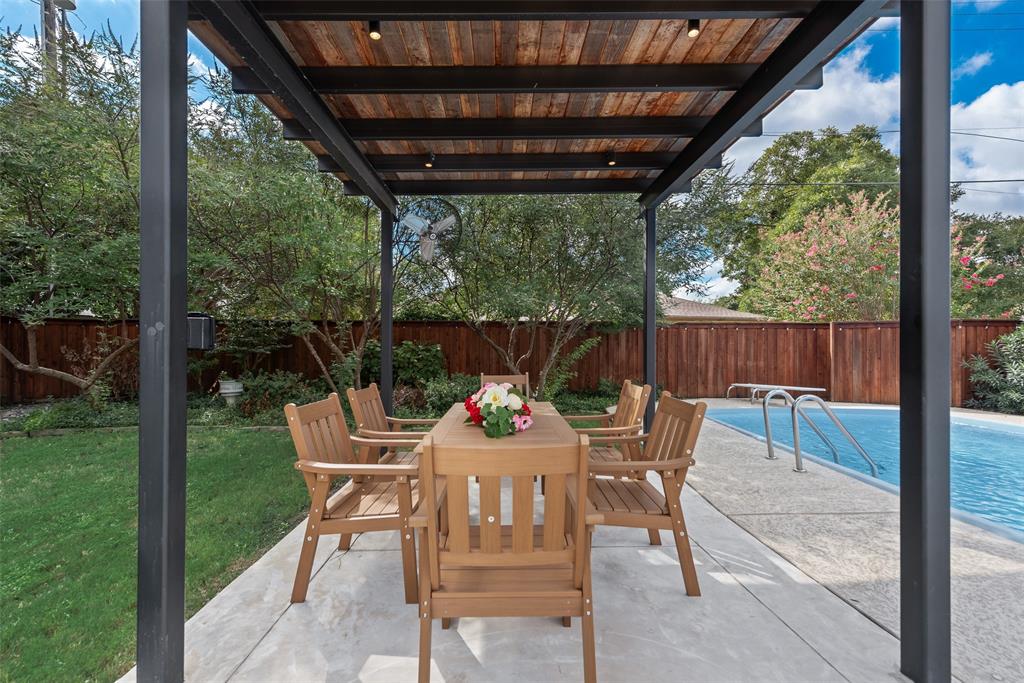 Covered outdoor patio with a wood-plank ceiling, black metal structural framing, recessed lighting, concrete pool deck, and a swimming pool