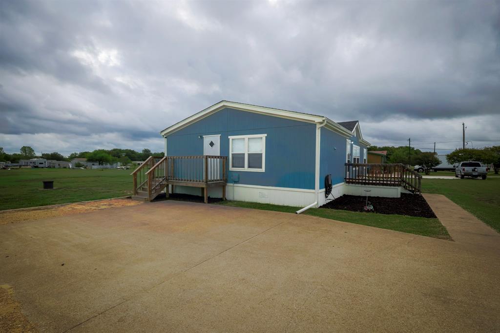 Exterior featuring blue siding, dual wooden elevated decks, and a concrete driveway